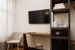 een kamer met een bureau, een tv en stoelen bij Feder Boutique Hotel in Lviv