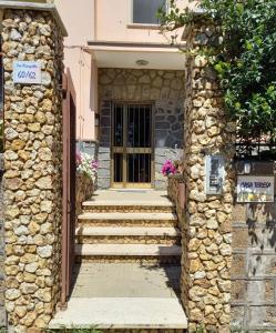 ein Steinhaus mit einer Treppe, die zu einer Tür führt in der Unterkunft Casa Teresa in Tarquinia
