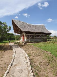 un gran edificio con techo en un campo en Masai Mara Explore Camp en Narok