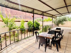 a patio with tables and chairs and a view of a river at Wadi rum village bed and breakfast in Wadi Rum