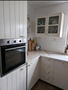 eine weiße Küche mit weißen Schränken und einem Herd in der Unterkunft Haus Natur in Markranstädt
