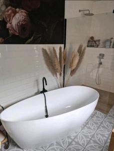 eine weiße Badewanne im Bad mit Gemälde in der Unterkunft Haus Natur in Markranstädt