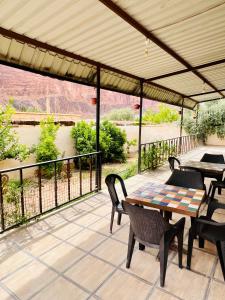 a patio with tables and chairs and a view of a river at Wadi rum village bed and breakfast in Wadi Rum