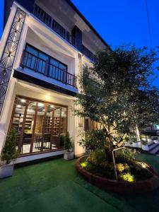 a house with a tree in front of it at Baannalin Hometel บ้านนลิน โฮมเทล in Chiang Mai