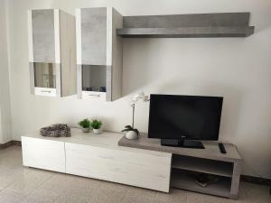een televisie op een witte kast in een kamer bij Casa Vacanza Orchidea in Trieste