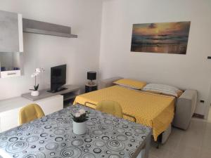 een kamer met een bed, een tafel en een televisie bij Casa Vacanza Orchidea in Trieste