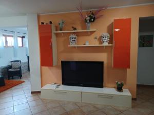 een woonkamer met een flatscreen-tv aan de muur bij CASA ORCHIDEA in Carlentini