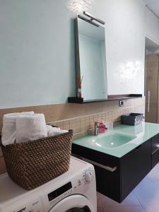 een badkamer met een wastafel en een wasmachine bij Casa Vacanza Orchidea in Trieste
