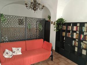 salon z czerwoną kanapą i półkami na książki w obiekcie Juventus Stadium - comfort e relax w Turynie