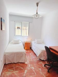 a room with two beds and a desk and a desk at 3 Habitación centro Huelva in Huelva