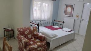 a small bedroom with a bed and a chair at HOLIDAYS APARTMENT ΜΕΣΣΗΝΗ in Messini