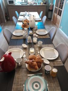 einen langen Tisch mit Tellern und Gebäck darauf in der Unterkunft Juliette's in Ypern