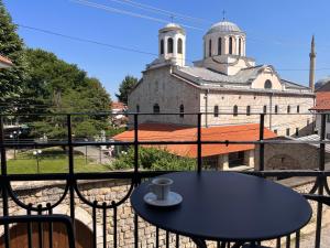 una mesa y sillas en un balcón con iglesia en Treva Hotel en Prizren