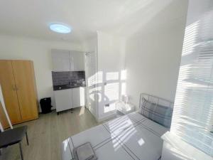 a white room with a table and a kitchen at Exeter Road Rooms in South Norwood