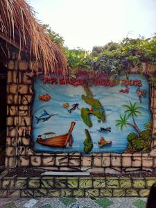 a mural on a wall with fish and a boat at P P Garden Home Bungalow in Phi Phi Don