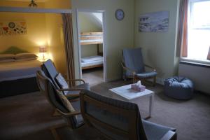 um quarto com cadeiras, uma cama e um espelho em Broadshade Holiday Apartments em Paignton