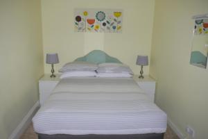 a bedroom with a bed with two lamps on it at Broadshade Holiday Apartments in Paignton