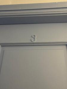 Una puerta blanca con el número seis. en Pensione Della Nonna, en Mykonos ciudad