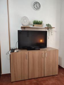 TV de pantalla plana en la parte superior de un armario de madera en Sunny Holiday Studio, en Málaga