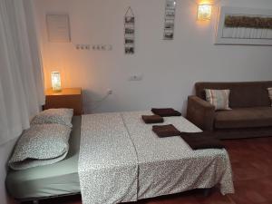 1 dormitorio con 2 camas y sofá en Sunny Holiday Studio, en Málaga