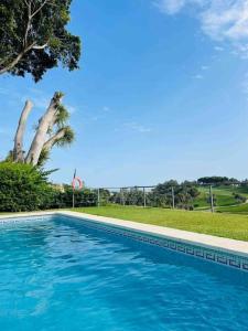 a swimming pool with blue water in a yard at Casa de 3 plantas, con jardín y vistas al golf in Benalmádena