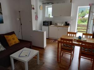 a living room with a couch and a table and a kitchen at Plitvice Valley Apartments in Ličko Petrovo Selo