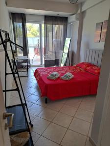 Schlafzimmer mit einem Bett mit roter Bettwäsche und einer Leiter in der Unterkunft Hestia Airport House - Artemis in Artemida