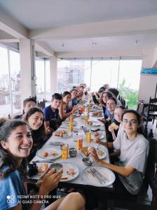 a group of people sitting at a long table eating at Lake View Lodge Sarangkot in Pokhara