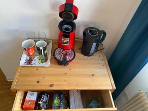 a table with a coffee maker and cups on it at Haus der Begegnung in Schieder-Schwalenberg