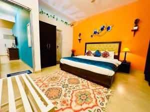 カンドリムにあるGR STAYS Sol Villa Candolim with Private Pool, Walking distance to Beachのオレンジ色の壁のベッドルーム1室、ベッド1台、ラグが備わります。 +26枚の写真