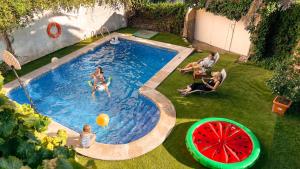 un grupo de personas jugando en una piscina con una sandía en Villa del Jerte, en El Torno