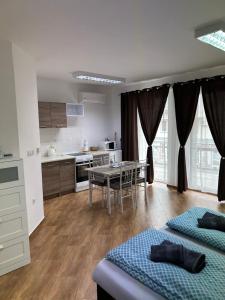 a kitchen and dining room with two beds and a table at Kondé Apartments B in Dunajská Streda