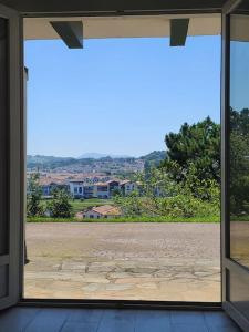a view of a field through a sliding glass door at Socoa : appartement calme à 200m de la plage in Ciboure