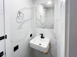 Multi Hostel Lavapies في مدريد: حمام أبيض مع حوض ومرآة