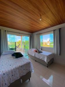 - une chambre avec 2 lits et une grande fenêtre dans l'établissement Casa PatachAmar, à Porto de Pedras