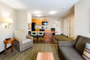 a living room with a couch and a kitchen at Candlewood Suites Savannah Airport, an IHG Hotel in Savannah