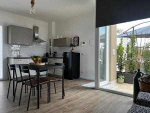 a kitchen with a table and a black refrigerator at L’angolo degli aromi in Ragusa