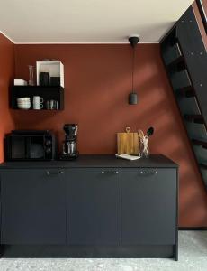 a kitchen with a black counter and a staircase at Villa Kivi in Valkeakoski