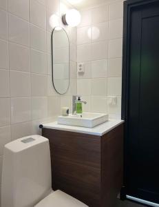 La salle de bains est pourvue de toilettes, d'un lavabo et d'un miroir. dans l'établissement Villa Kivi, à Valkeakoski