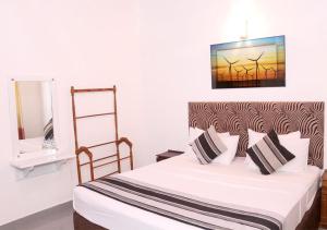 Cozy Inn Negombo في نيجومبو: غرفة نوم بسرير ومرآة