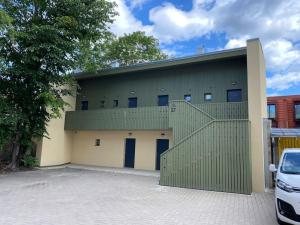 a building with a green fence and a parking lot at Cozy flat at Tartu Old Town in Tartu