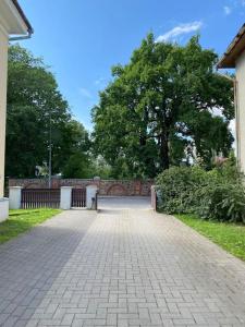 a brick walkway in a park with a fence and trees at Cozy flat at Tartu Old Town in Tartu