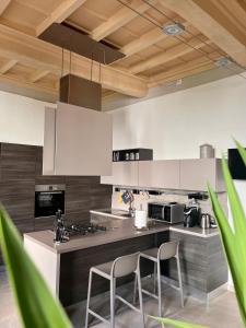 una cucina con armadi bianchi e 2 sedie di Dimora Boezio7, cozy and charming place in center with private parking a Pavia
