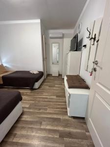 um pequeno quarto com 2 camas e um frigorífico em Къща за гости ЕМА em Vetren Dol