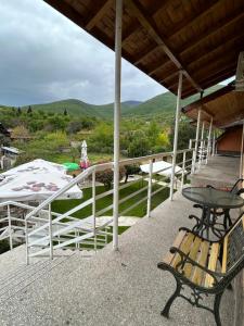 un porche con mesa, banco y montañas en Къща за гости ЕМА, en Vetren Dol