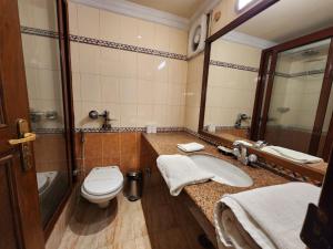 a bathroom with a toilet and a sink at Palace On Ganges - Heritage Hotel in Varanasi +36 photos