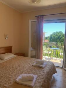 a bedroom with a bed with a view of a balcony at Dionysios Studios in Skala
