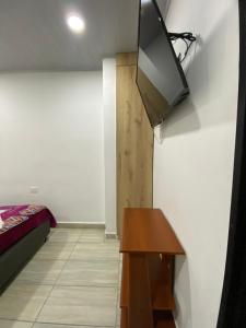 Habitación con cama y TV en la pared. en Apartamento guatape, en Guatapé