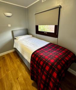 a small bedroom with a bed and a window at Lagavulin 3 in Portpatrick