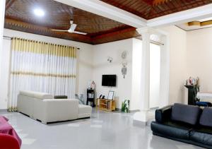 Cozy Inn Negombo في نيجومبو: غرفة معيشة مع أريكة وتلفزيون